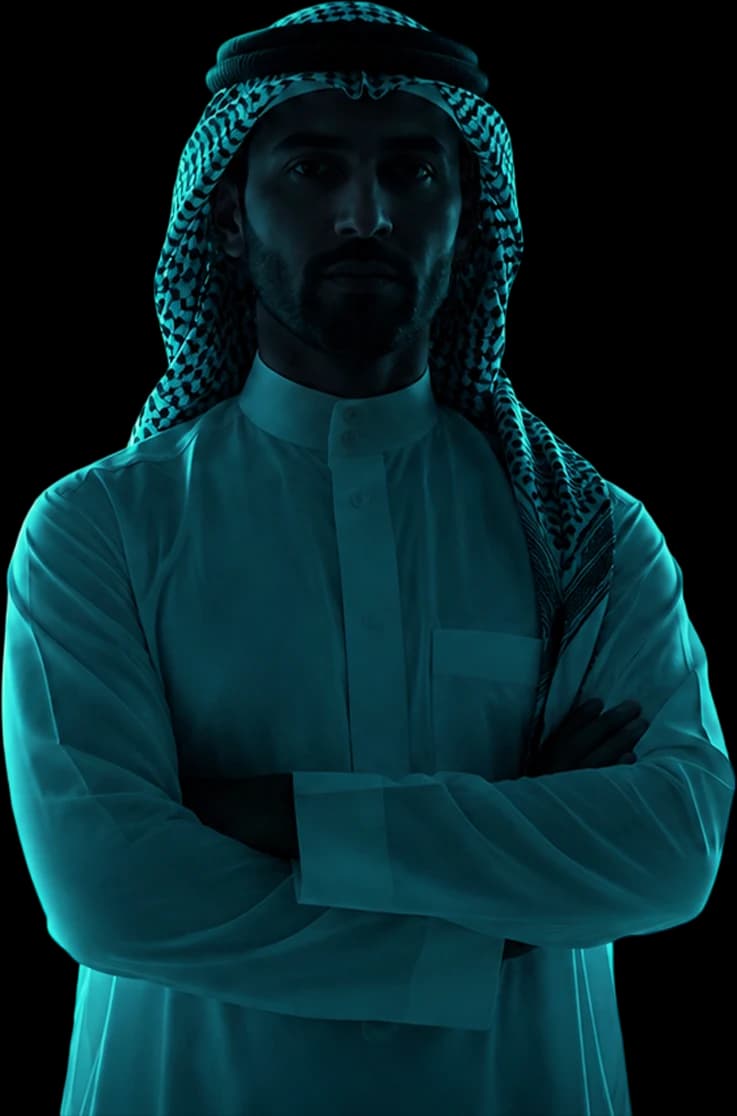 A man in traditional Saudi dress standing before the Riyadh skyline
